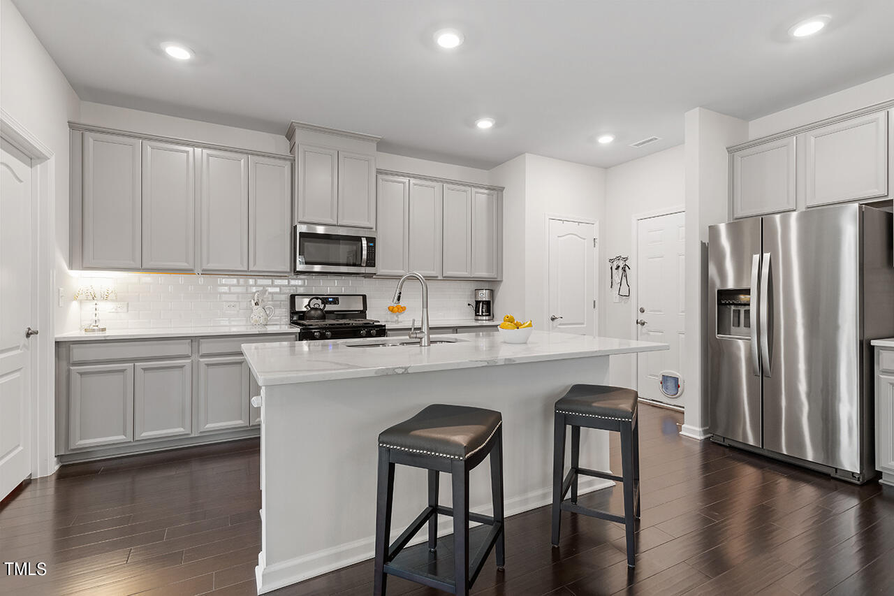 1157 Chestnut Bluff Apex, NC 27502 - Photo 11 of 42 a kitchen with stainless steel appliances granite countertop a white cabinets and a refrigerator