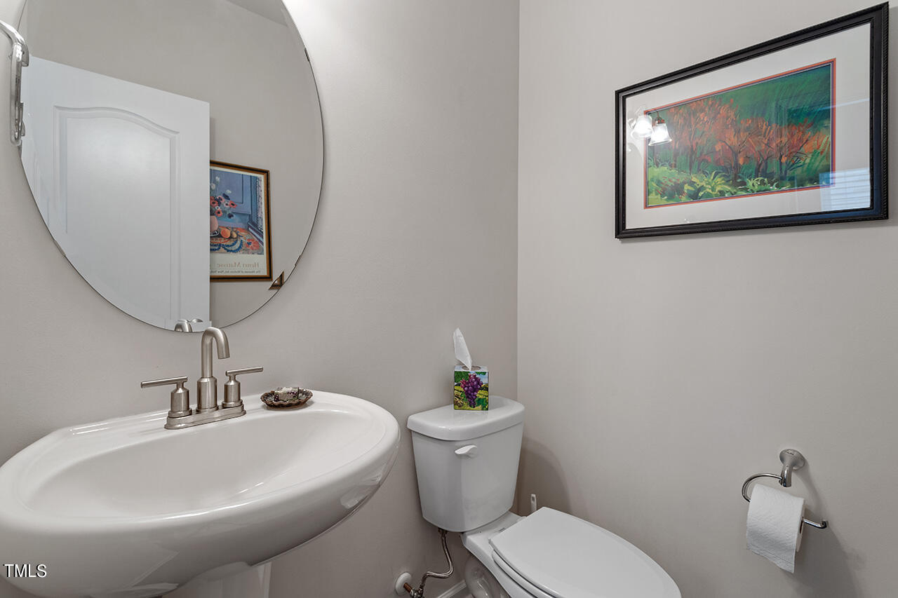 1157 Chestnut Bluff Apex, NC 27502 - Photo 17 of 42 a bathroom with a toilet a sink and mirror