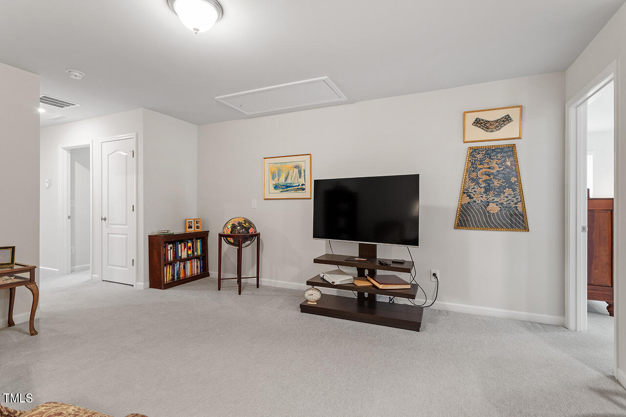 1157 Chestnut Bluff Apex, NC 27502 - Photo 18 of 42 a living room with furniture and a flat screen tv