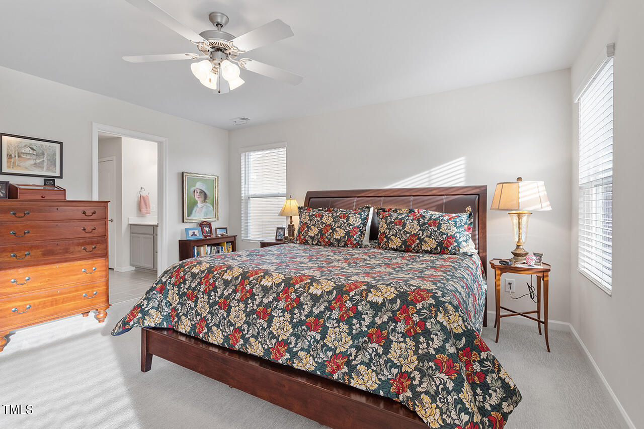 1157 Chestnut Bluff Apex, NC 27502 - Photo 21 of 42 a bed sitting in a bedroom next to a window with a large bed and a chandelier