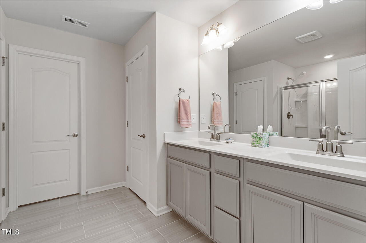 1157 Chestnut Bluff Apex, NC 27502 - Photo 25 of 42 a bathroom with a double vanity sink and a mirror