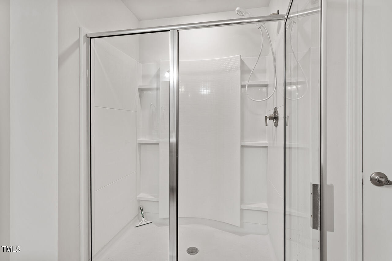 1157 Chestnut Bluff Apex, NC 27502 - Photo 27 of 42 a bathroom with a glass shower door