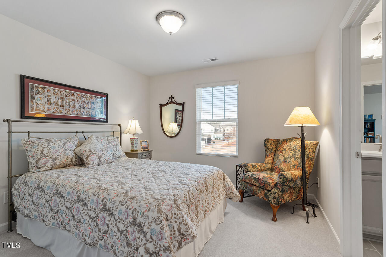 1157 Chestnut Bluff Apex, NC 27502 - Photo 29 of 42 a bedroom with a bed couch chandelier and a window