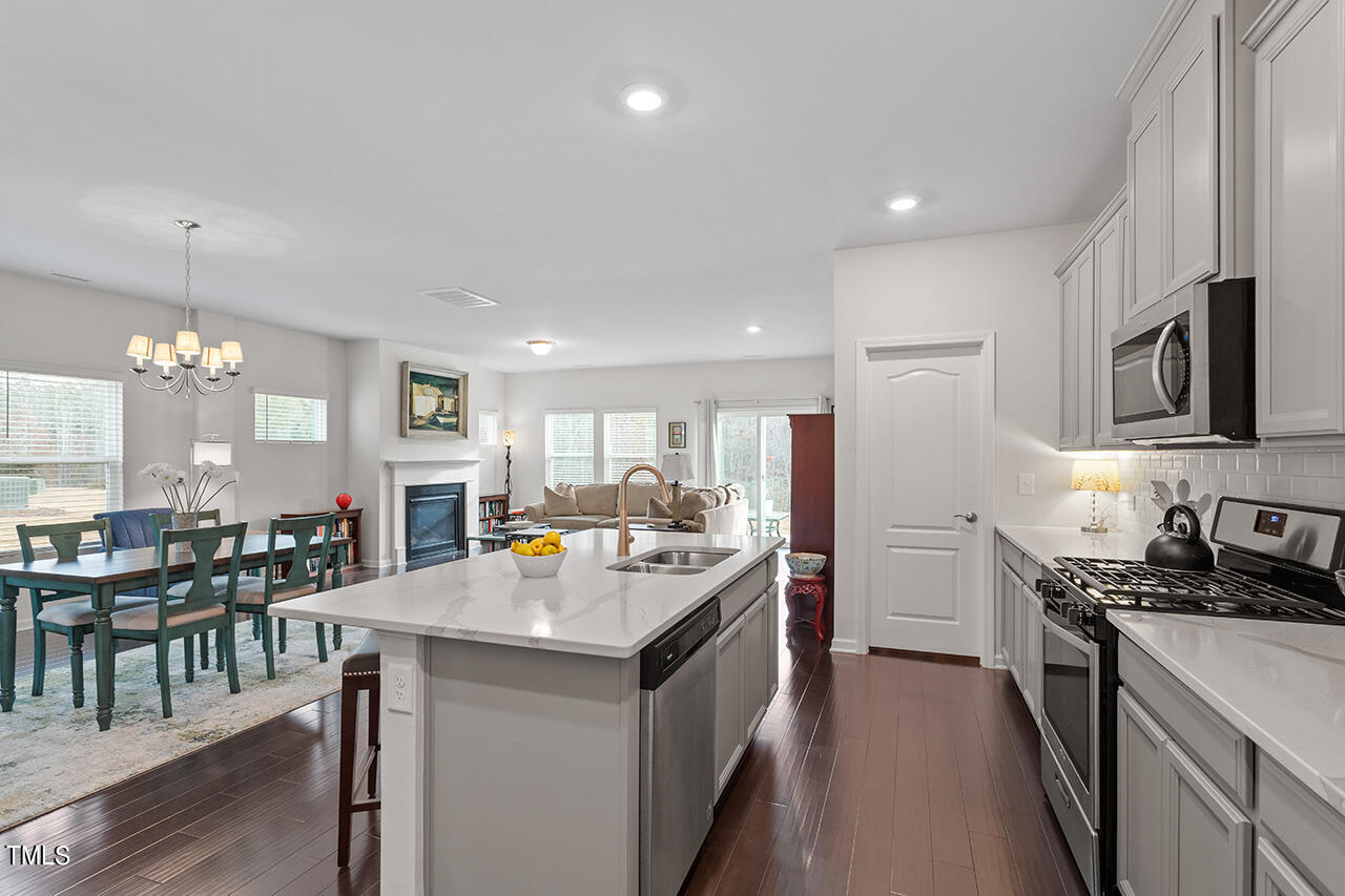 1157 Chestnut Bluff Apex, NC 27502 - Photo 7 of 42 a kitchen with stainless steel appliances a sink stove and refrigerator