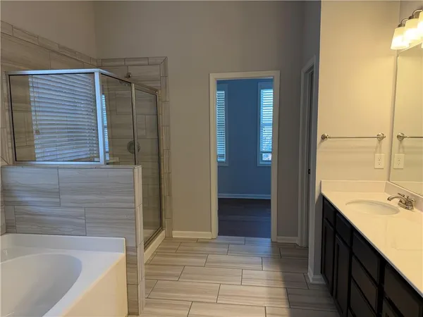 a bathroom with a tub sink and mirror