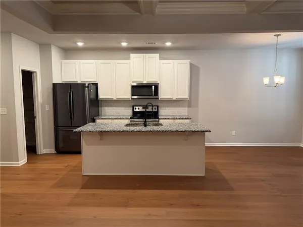 a large kitchen with stainless steel appliances granite countertop a stove a refrigerator and a sink