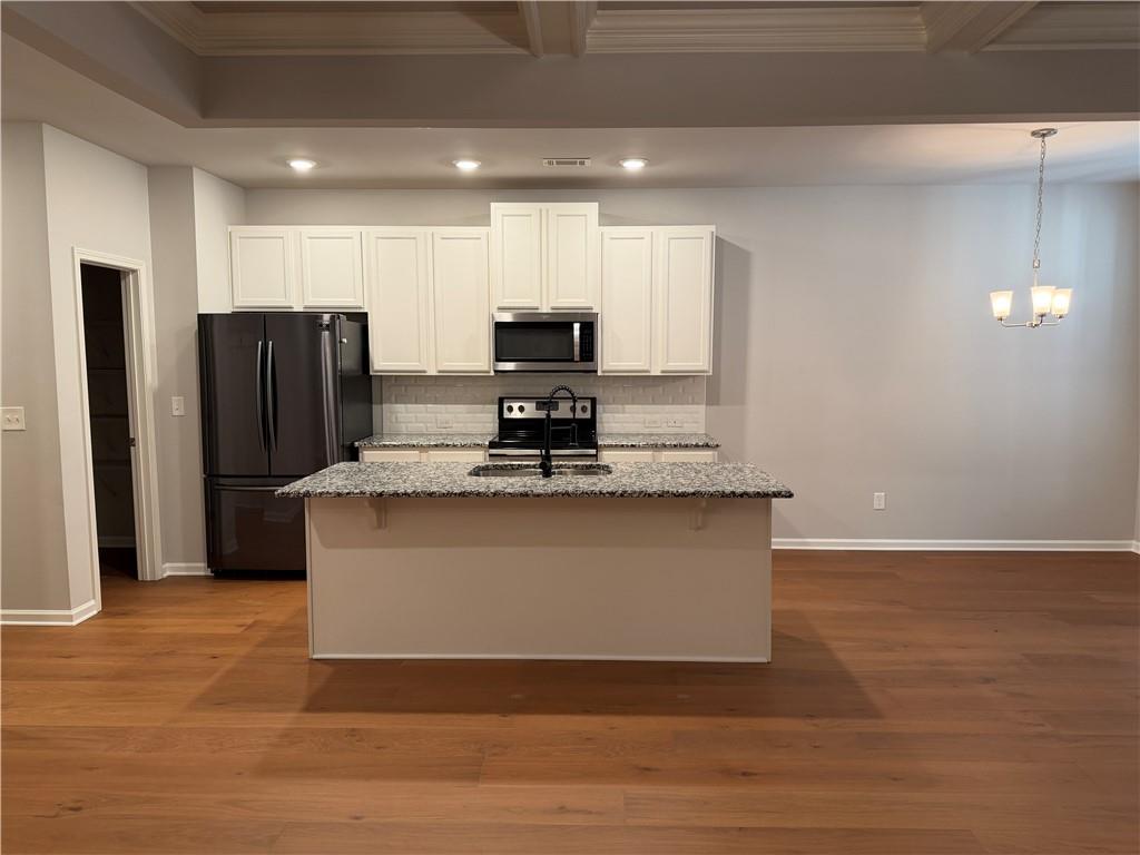 7811 Silk Tree Pointe Braselton, GA 30517 - Photo 6 of 20 a large kitchen with stainless steel appliances granite countertop a stove a refrigerator and a sink