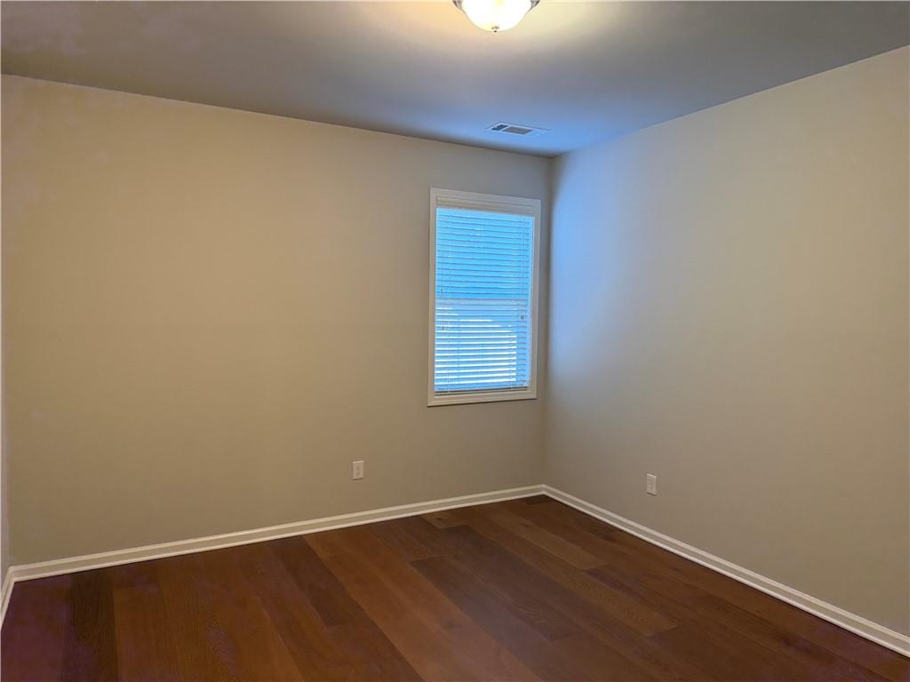 7811 Silk Tree Pointe Braselton, GA 30517 - Photo 9 of 20 a view of an empty room with wooden floor and a window