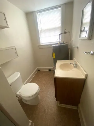 a bathroom with a toilet sink and mirror