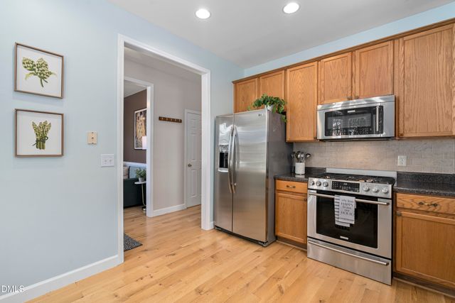 a kitchen with granite countertop white cabinets and stainless steel appliances