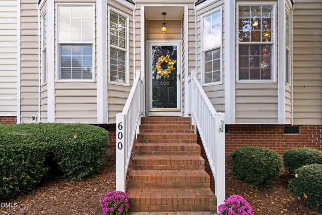 a view of a house with entryway and flower plants