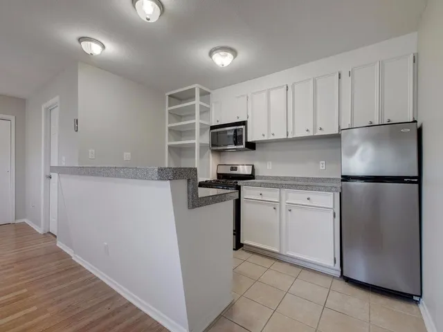 a kitchen with stainless steel appliances granite countertop a sink stove and microwave