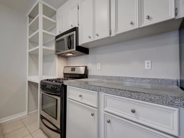 a kitchen with granite countertop a stove and a sink