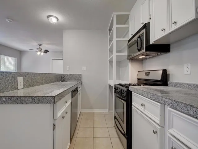 a kitchen with stainless steel appliances granite countertop a sink and a stove