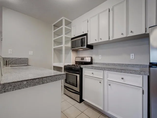 a kitchen with stainless steel appliances a stove a microwave and a refrigerator