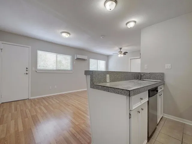 a view of empty room with wooden floor and ceiling fan