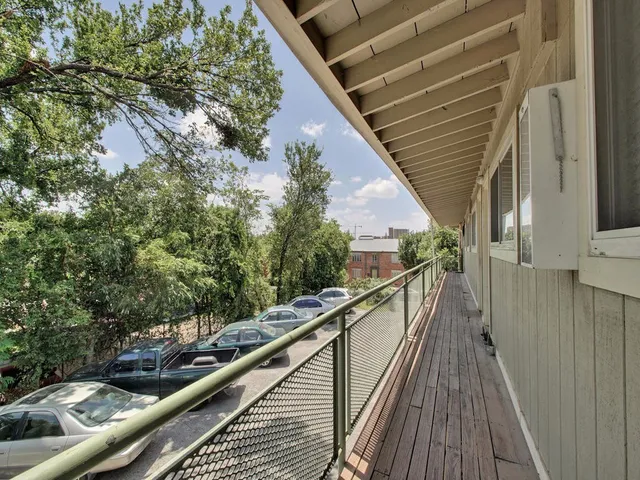 a view of balcony with wooden floor and fence