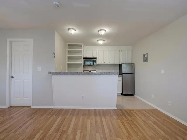 a kitchen with stainless steel appliances granite countertop white cabinets and black stove top oven with granite countertops