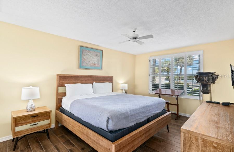 605 Sutton Place, Unit 102 Longboat Key, FL 34228 - Photo 12 of 29 a bedroom with a bed and wooden floor