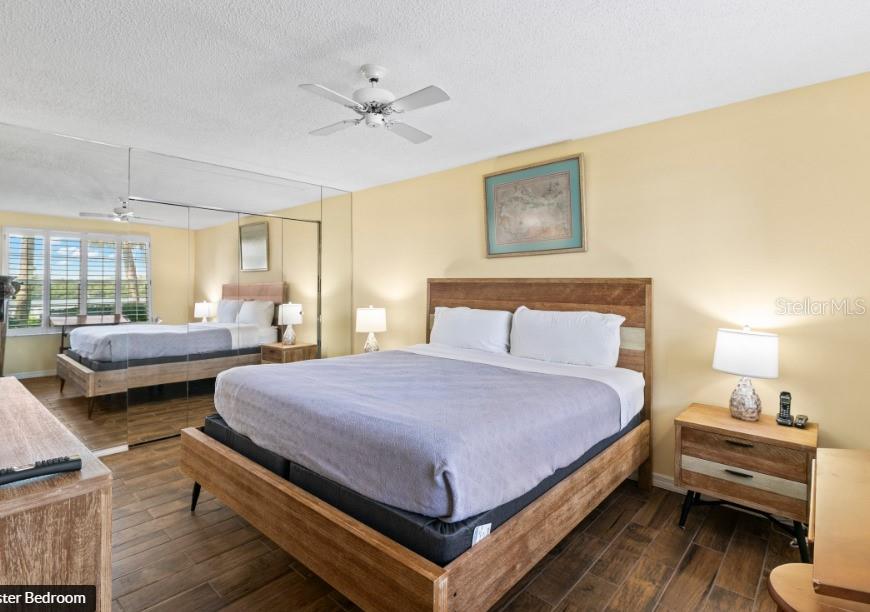 605 Sutton Place, Unit 102 Longboat Key, FL 34228 - Photo 14 of 29 a bedroom with a bed and a couch