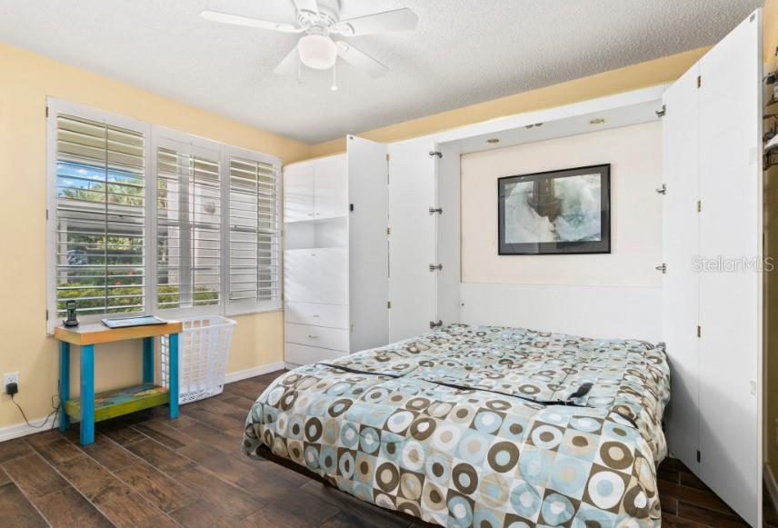 605 Sutton Place, Unit 102 Longboat Key, FL 34228 - Photo 17 of 29 a bedroom with a large bed and a flat tv screen