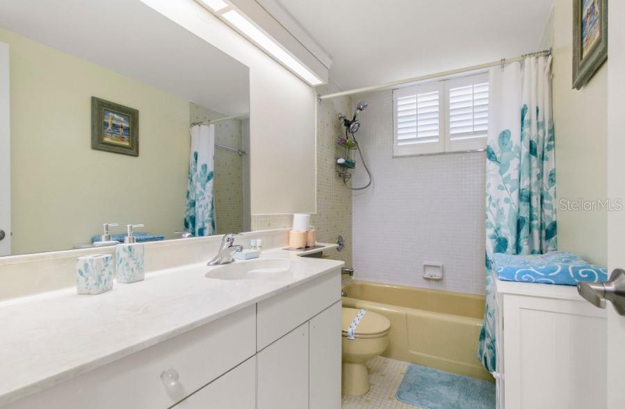 605 Sutton Place, Unit 102 Longboat Key, FL 34228 - Photo 18 of 29 a bathroom with a granite countertop sink toilet and shower