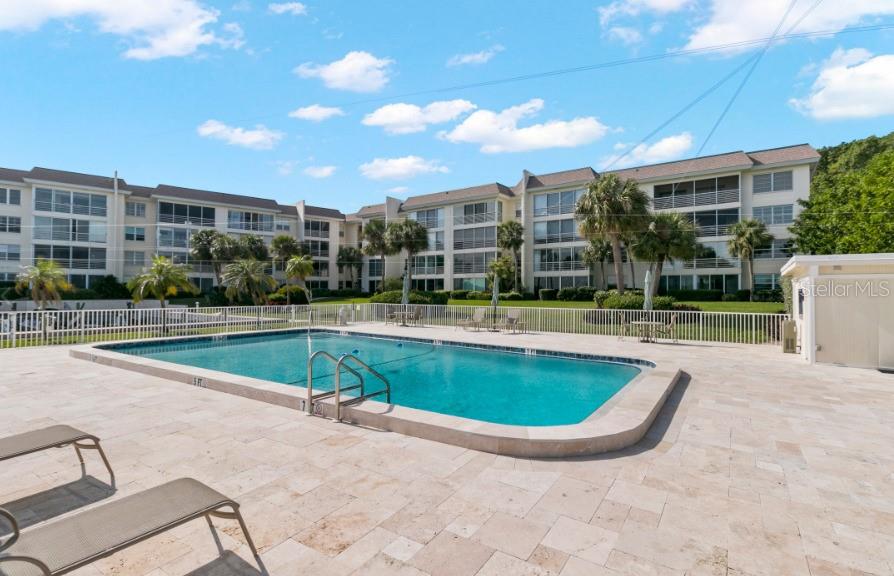 605 Sutton Place, Unit 102 Longboat Key, FL 34228 - Photo 22 of 29 a view of a swimming pool with a patio and a yard