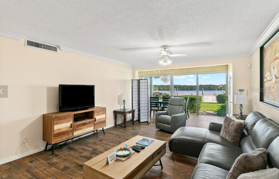 605 Sutton Place, Unit 102 Longboat Key, FL 34228 - Photo 3 of 29 a living room with furniture and a flat screen tv