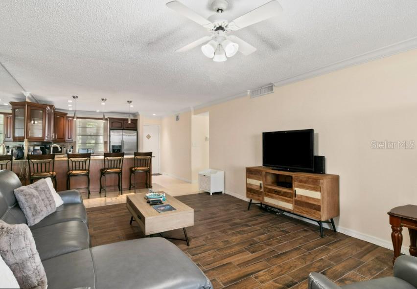 605 Sutton Place, Unit 102 Longboat Key, FL 34228 - Photo 4 of 29 a living room with furniture and a flat screen tv