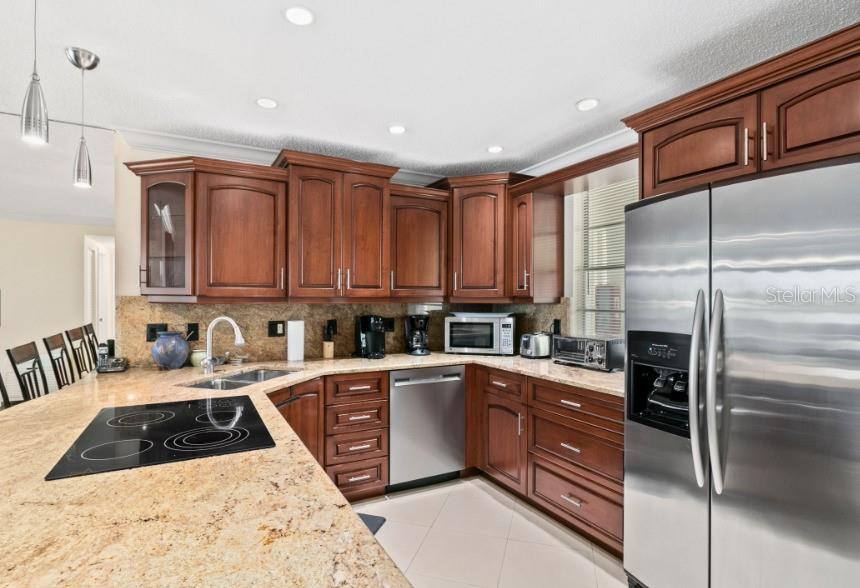 605 Sutton Place, Unit 102 Longboat Key, FL 34228 - Photo 8 of 29 a kitchen with a sink a stove and cabinets