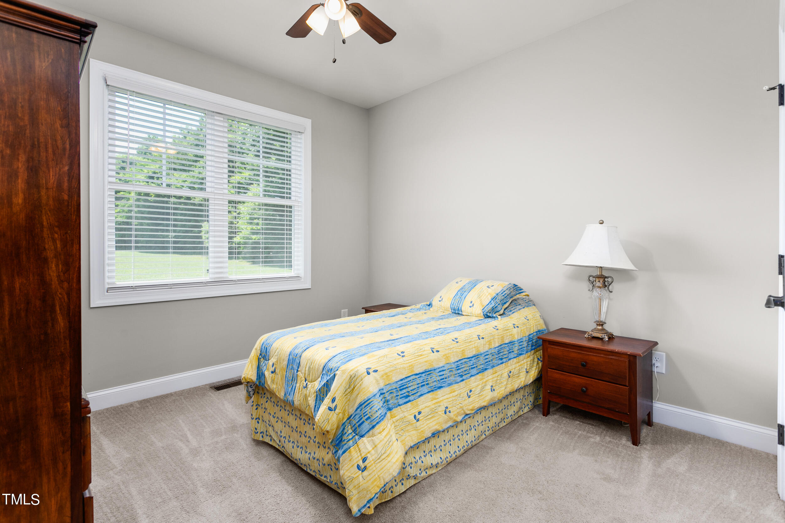 4455 Boyd Wright Road Burlington, NC 27215 - Photo 25 of 40 a bedroom with a bed and a chandelier