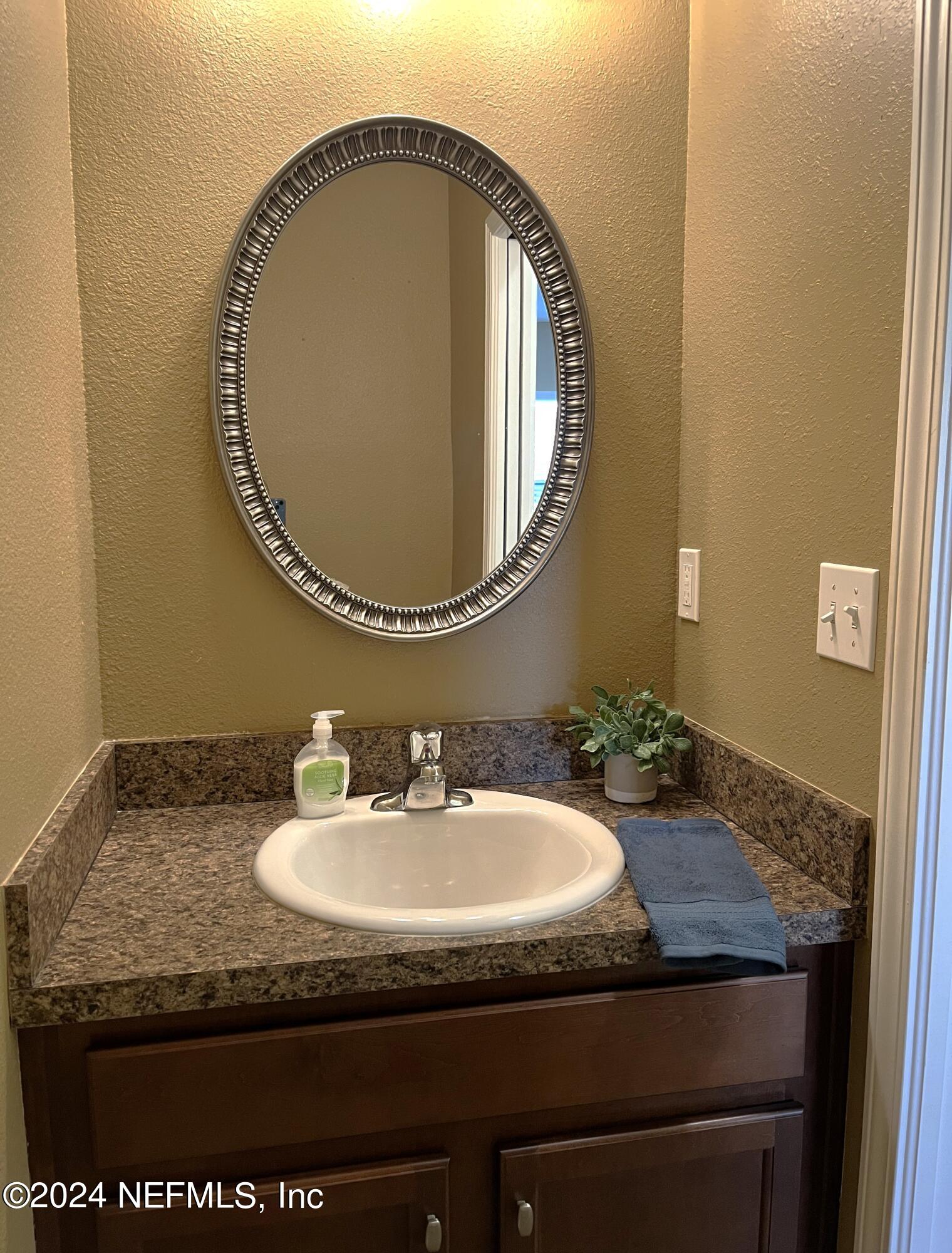 294 Buck Run Way St. Augustine, FL 32092 - Photo 14 of 22 a bathroom with a granite countertop sink and a mirror