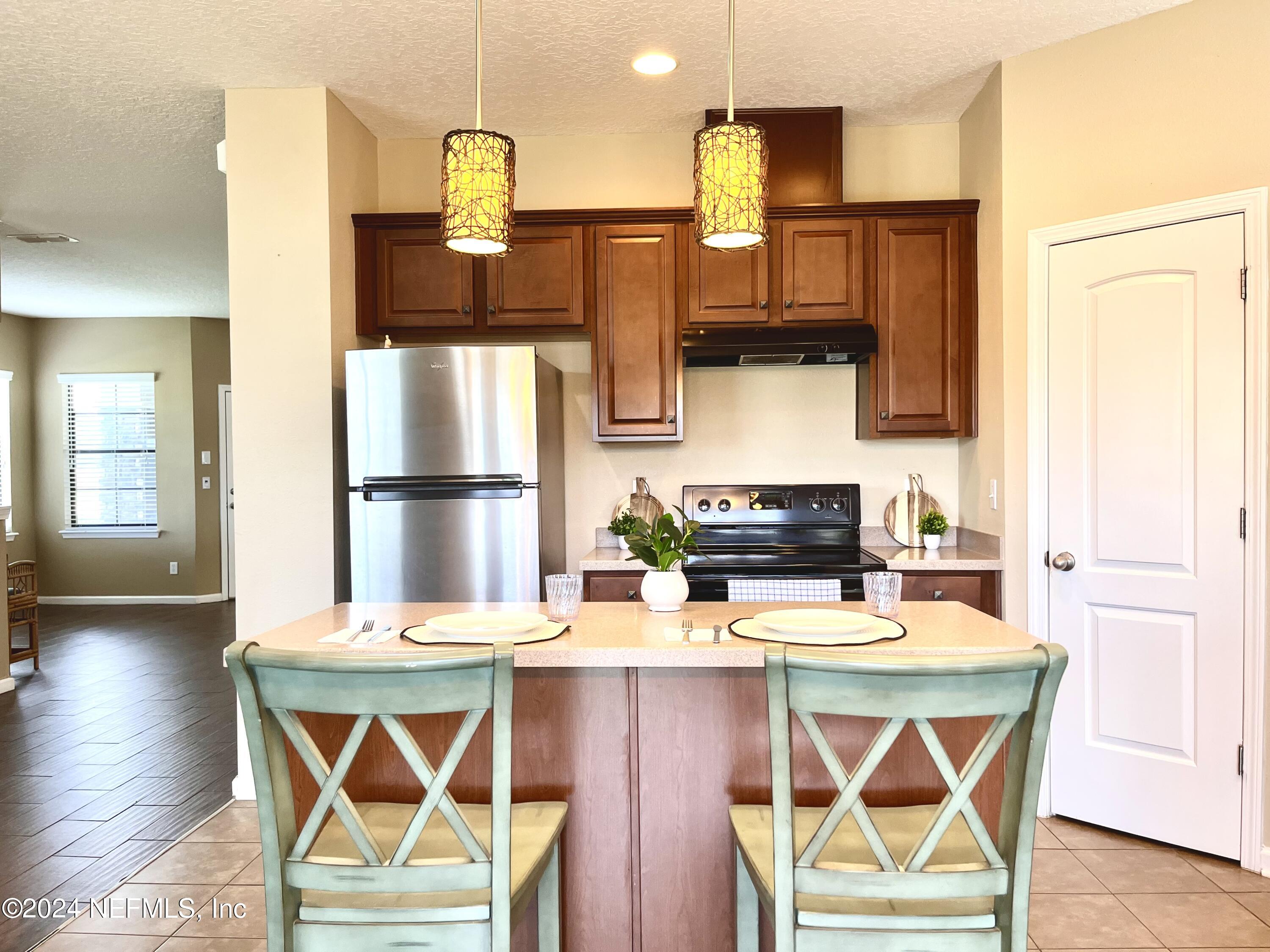 294 Buck Run Way St. Augustine, FL 32092 - Photo 5 of 22 a kitchen with stainless steel appliances wooden floor and refrigerator