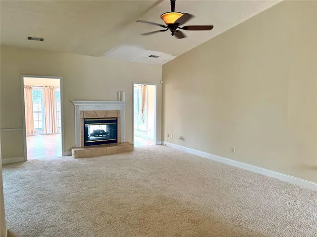a view of an empty room with a fireplace and a window