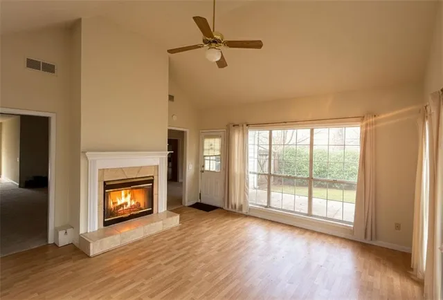 a view of an empty room with a fireplace and a window