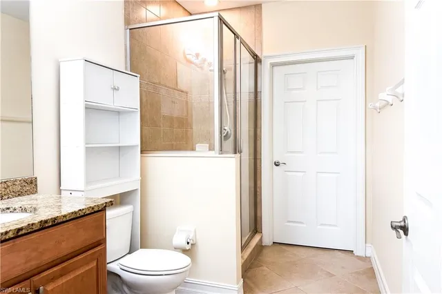 a bathroom with a granite countertop sink toilet and shower