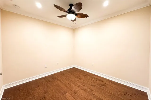 a view of a room with wooden floor and a ceiling fan