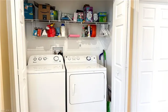 a utility room with dryer washer and a fridge