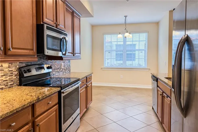 a kitchen with stainless steel appliances granite countertop a stove a sink and a microwave