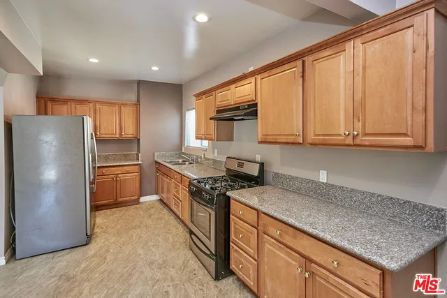 a kitchen with stainless steel appliances granite countertop a refrigerator sink and cabinets