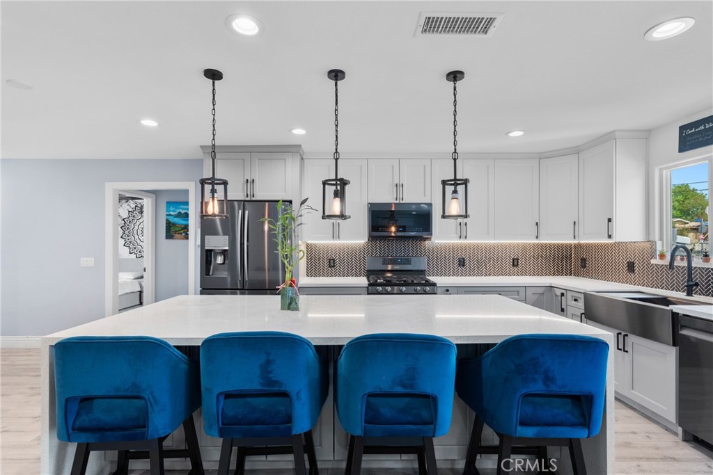 609 La Seda Road La Puente, CA 91744 - Photo 8 of 34 a kitchen with stainless steel appliances a dining table chairs stove and refrigerator