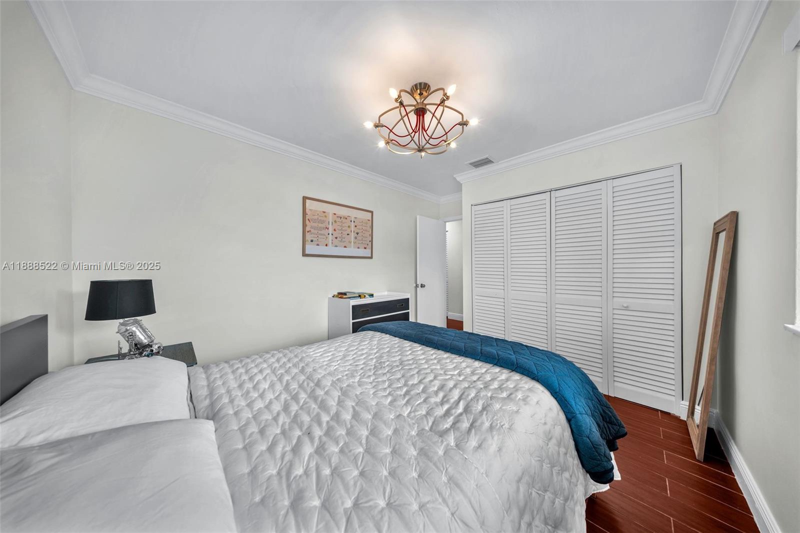 11006 Southwest 138th Place Miami, FL 33186 - Photo 41 of 47 a bedroom with a bed and a chandelier