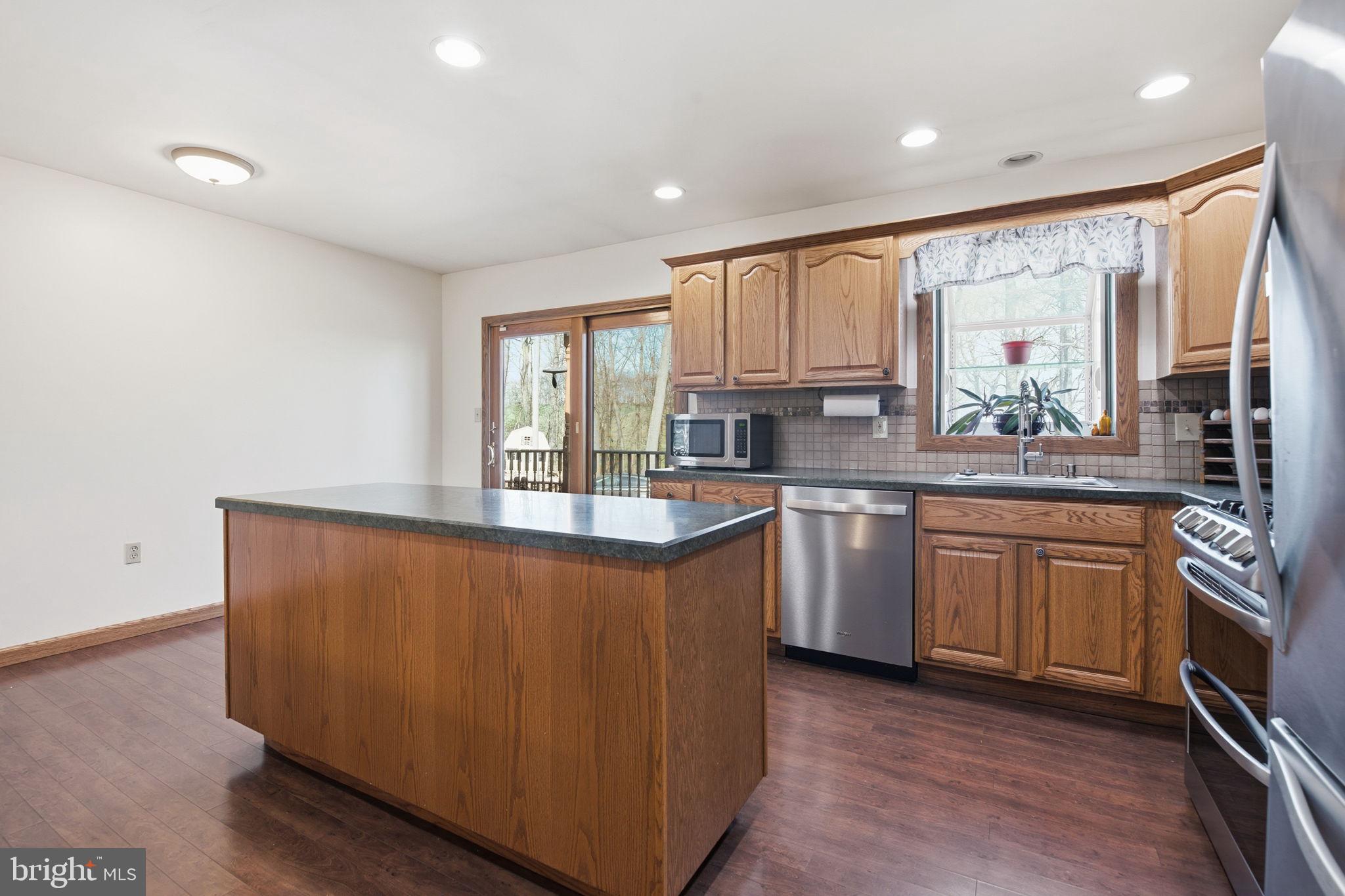 6501 Fair School Road Glen Rock, PA 17327 - Photo 7 of 43 a kitchen with stainless steel appliances granite countertop a refrigerator a sink dishwasher a oven with white cabinets and wooden floor