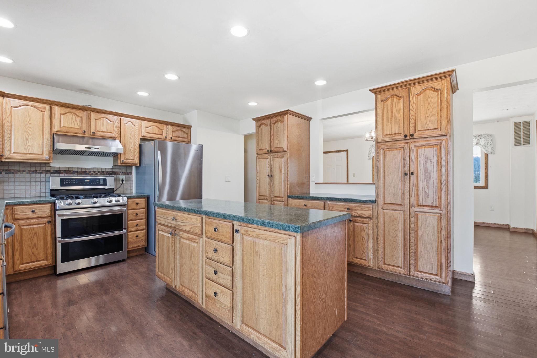 6501 Fair School Road Glen Rock, PA 17327 - Photo 8 of 43 a kitchen with stainless steel appliances granite countertop a refrigerator stove and wooden cabinets