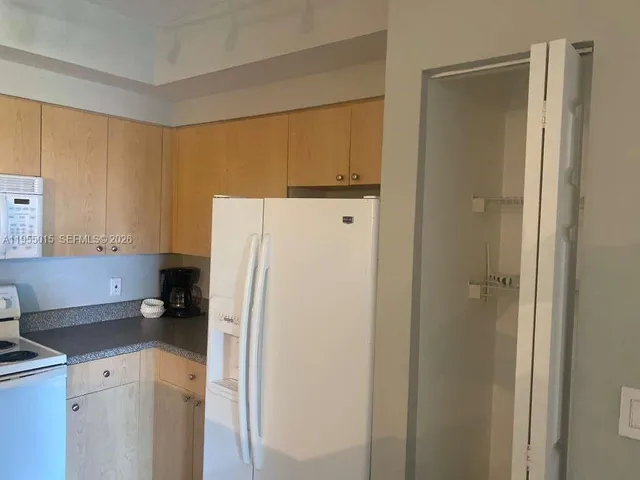 a white refrigerator freezer sitting in a kitchen