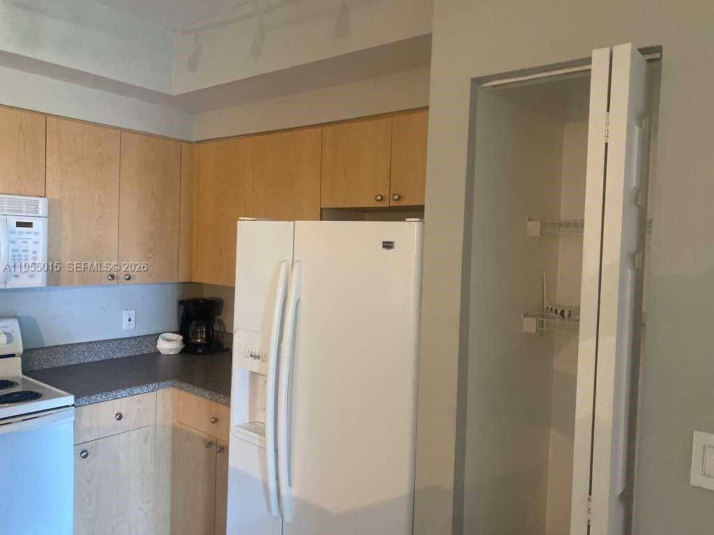 7930 North Nob Hill Road, Unit 304 Tamarac, FL 33321 - Photo 11 of 30 a white refrigerator freezer sitting in a kitchen