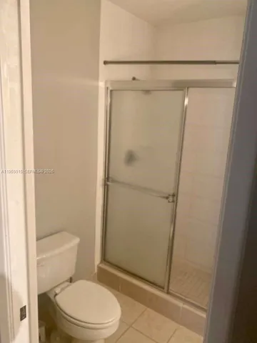 a white toilet sitting next to a shower