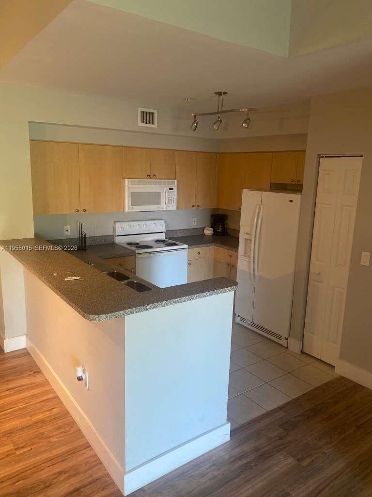 7930 North Nob Hill Road, Unit 304 Tamarac, FL 33321 - Photo 9 of 30 a kitchen with stainless steel appliances granite countertop a sink a stove a refrigerator and a microwave