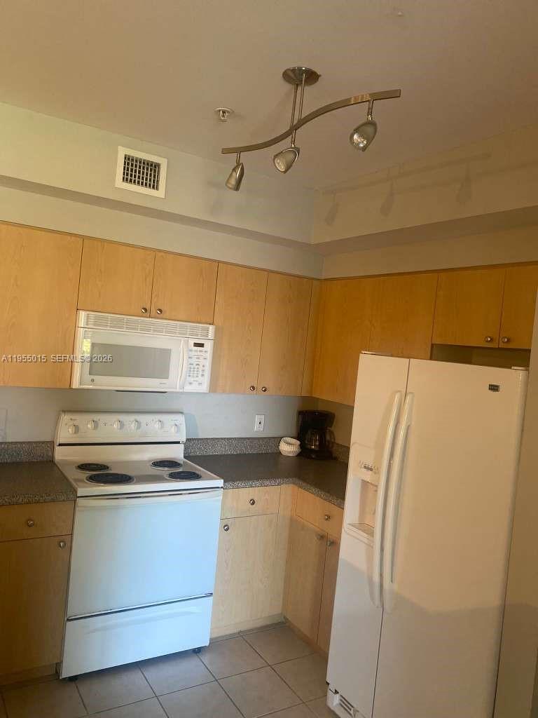 7930 North Nob Hill Road, Unit 304 Tamarac, FL 33321 - Photo 10 of 30 a kitchen with a refrigerator and a stove