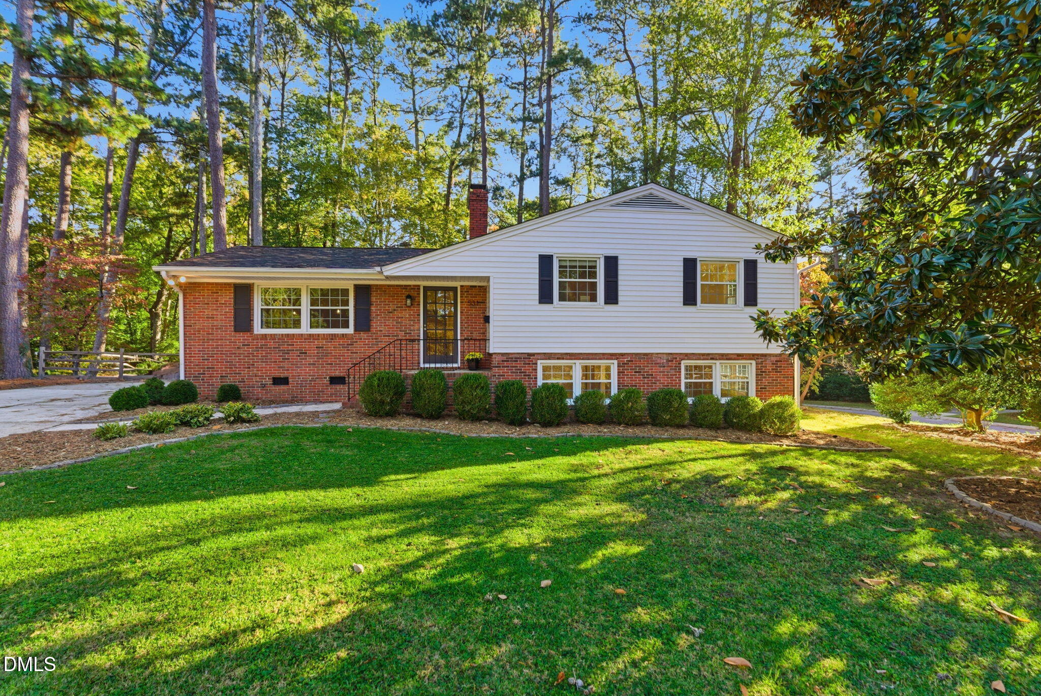 a front view of a house with a yard and trees